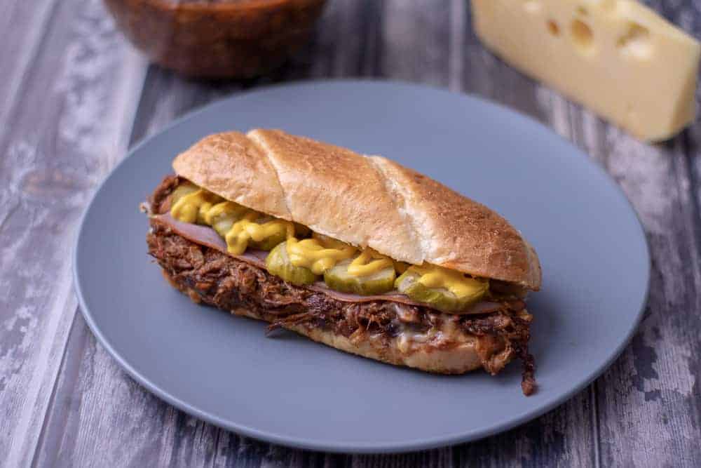 BBQ pulled pork cuban sandwich on a blue plate.