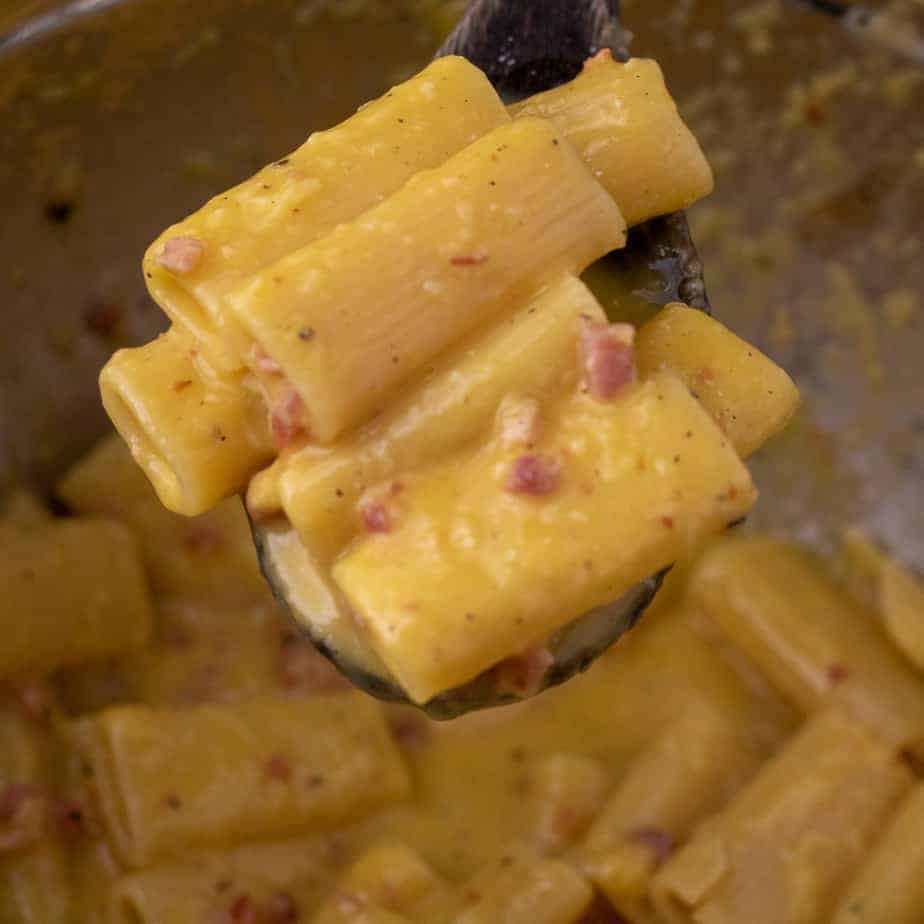Close up of pasta carbonara in a mixing bowl