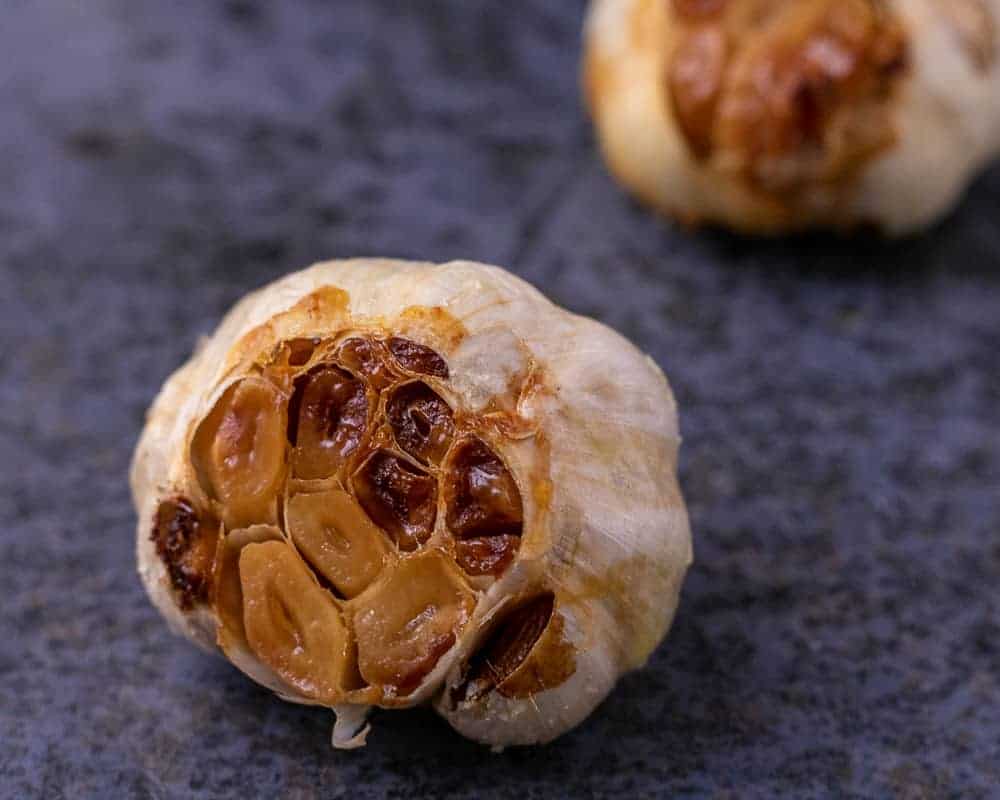 A close up of a head of roasted garlic