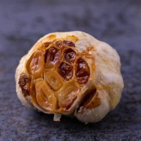 A close up of a head of roasted garlic