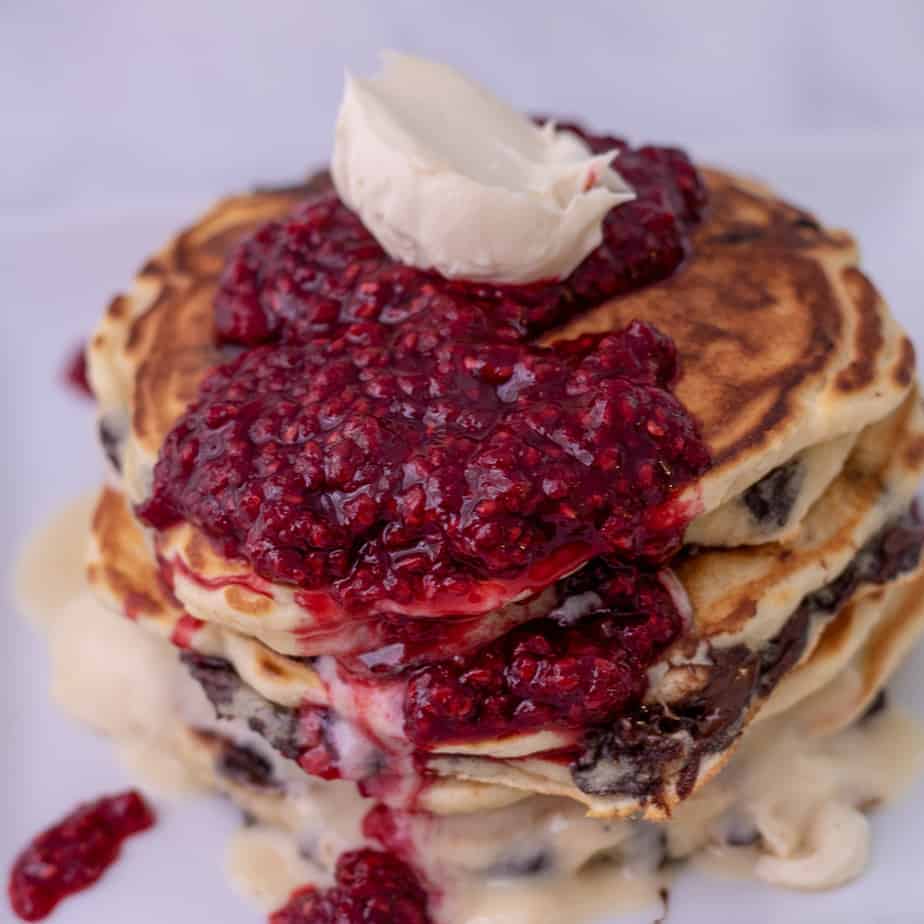 Side view of pancakes with mascarpone, chocolate chips and raspberries