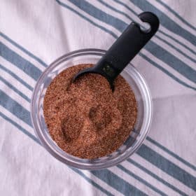 A bowl of taco seasoning with a black measuring spoon