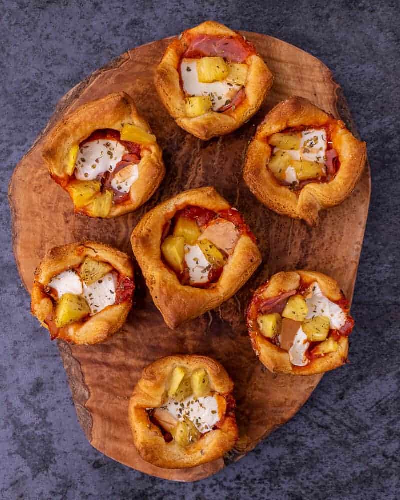 Hawaiian pizza muffins on a wooden serving board