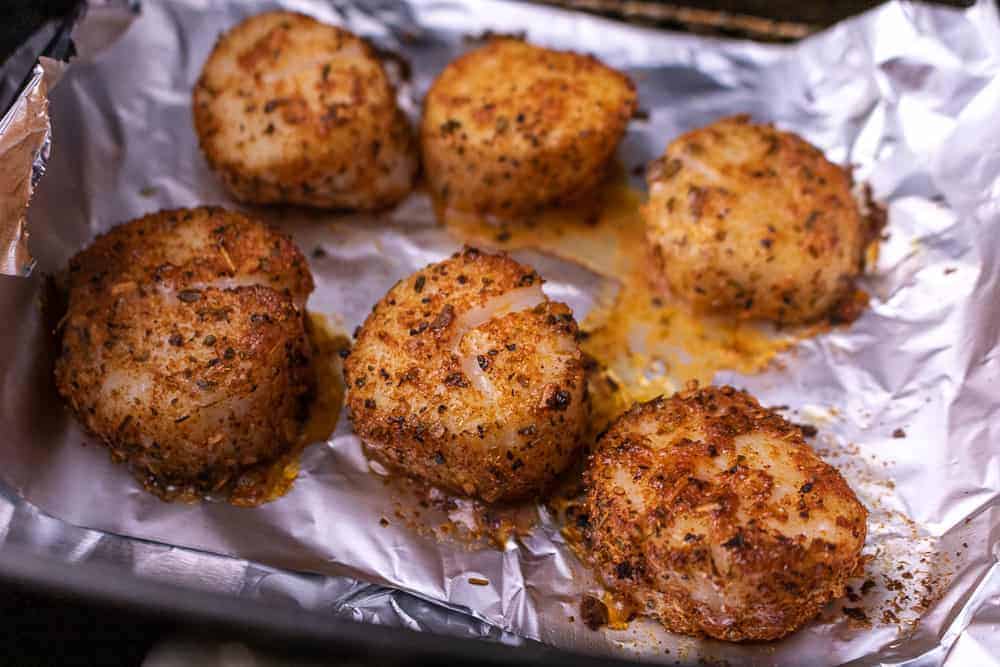 Air fryer cajun scallops in the air fryer basket.