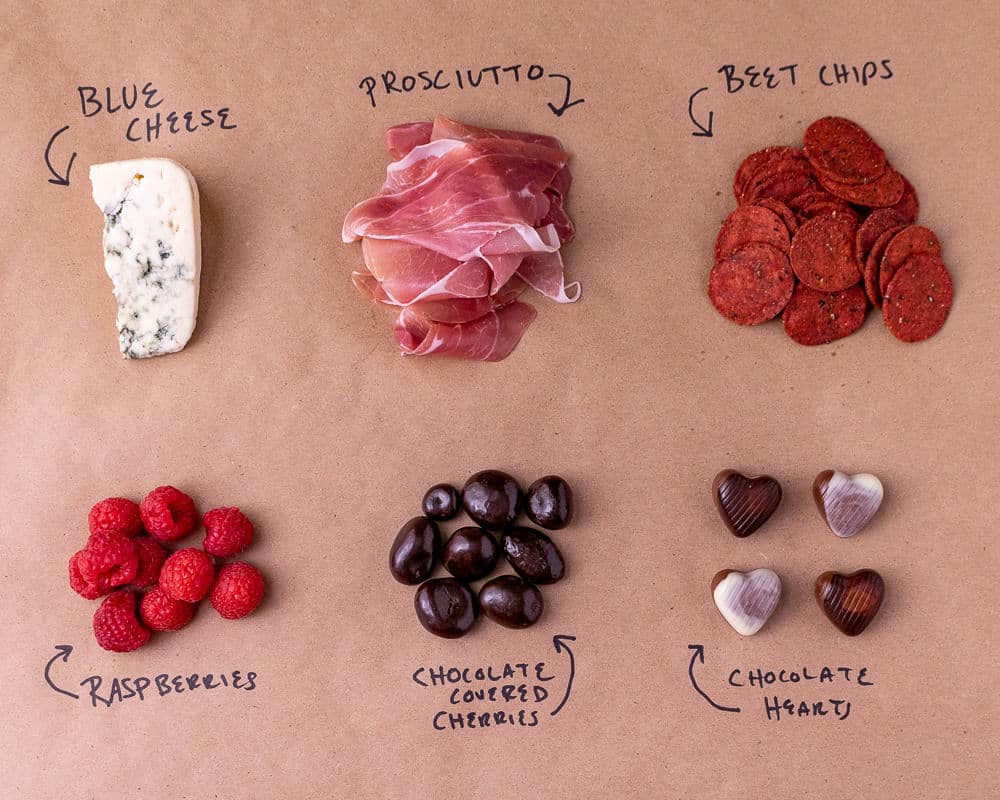 The ingredients for the cheese plate on a brown background laid out