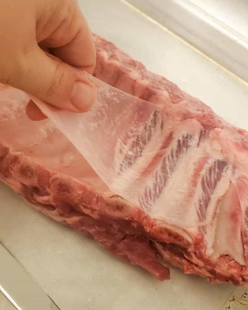 Taking the membrane off a rack of ribs.