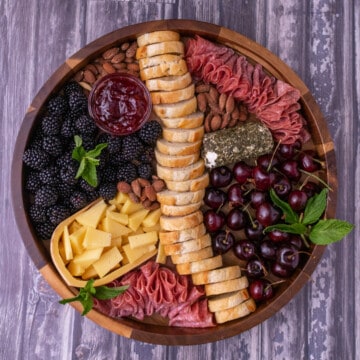 Finished summer cheese plate on a wooden board.