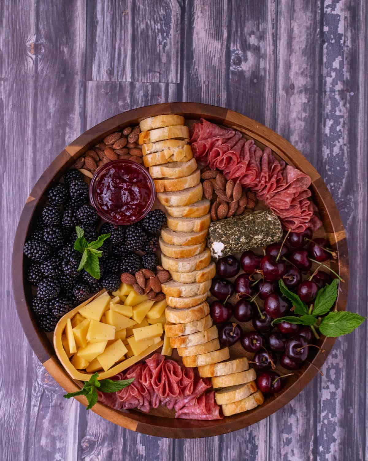 Finished summer cheese plate on a wooden board.