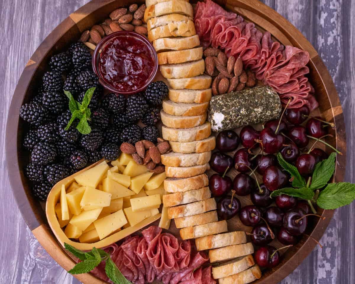 Finished summer cheese plate on a wooden board.