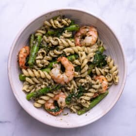 A white bowl of lemon pesto pasta with shrimp