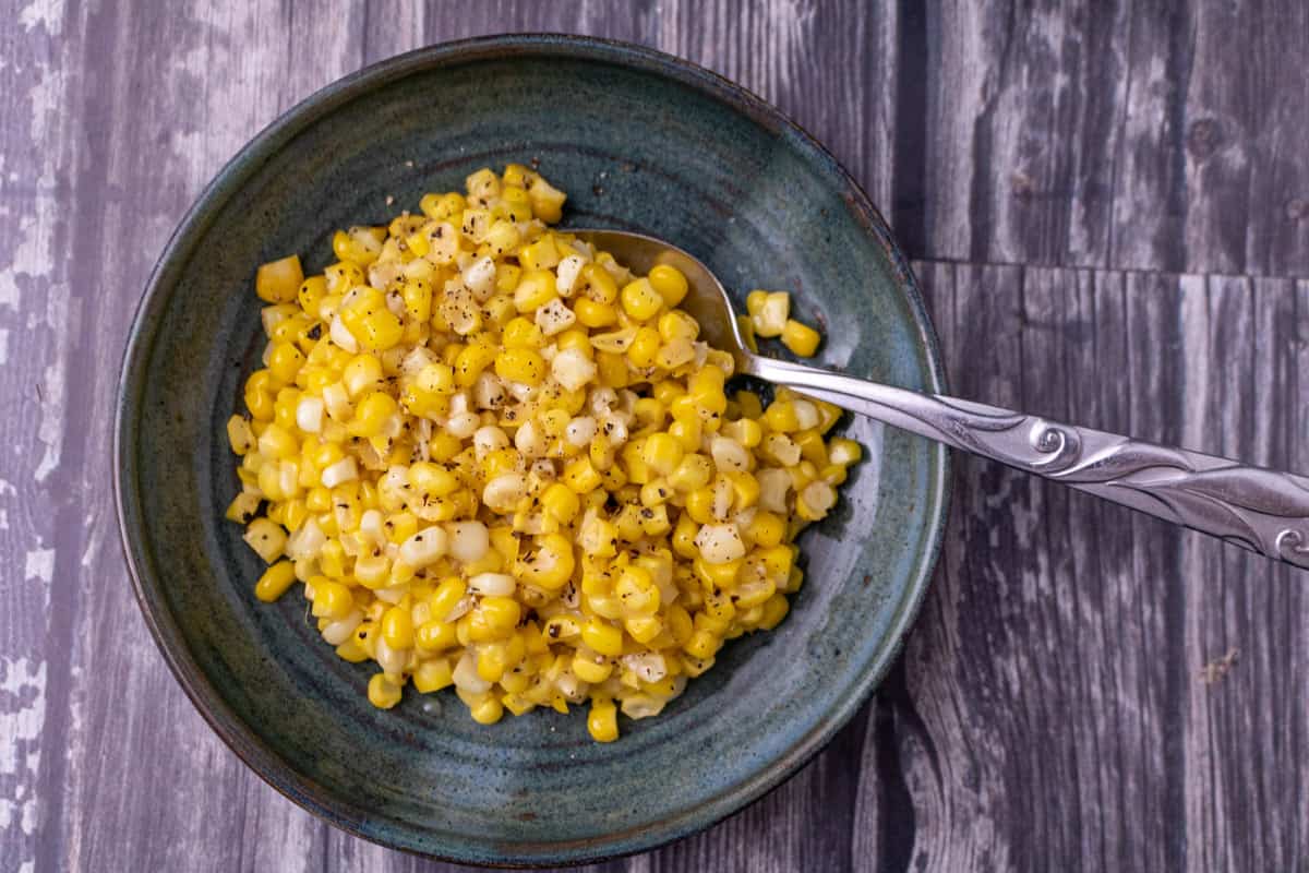 Miso butter corn on a green plate with a spoon