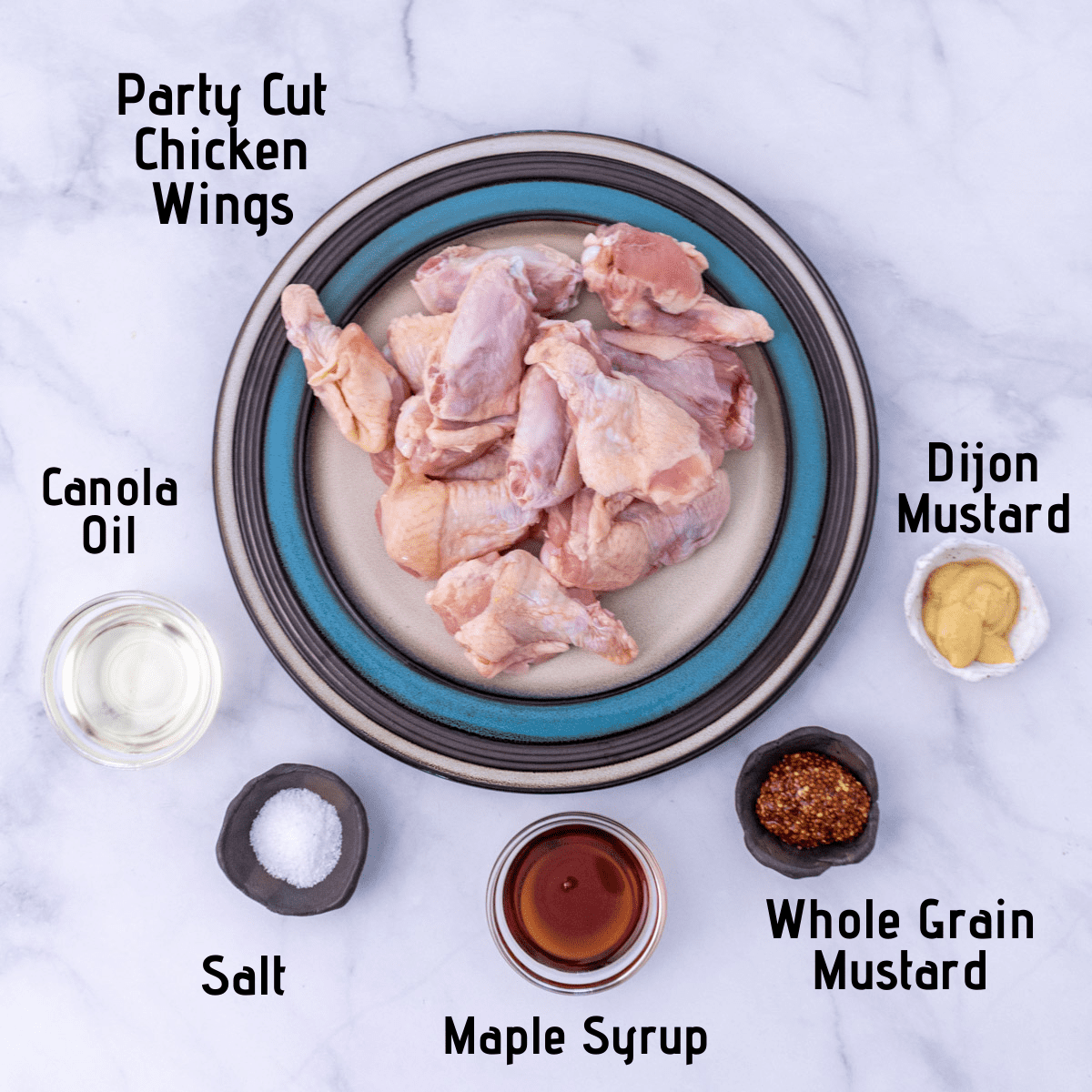 Raw ingredients laid out and labeled, chicken wings, dijon mustard, whole grain mustard, maple syrup, kosher salt and canola oil.
