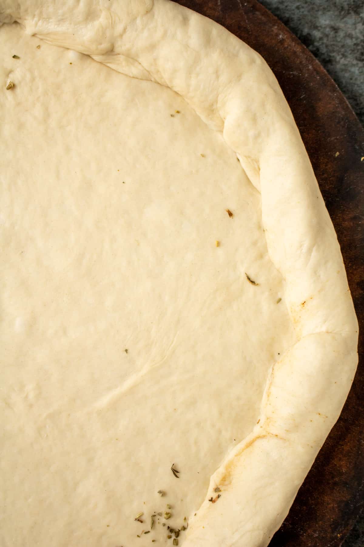 A close up photo of the sealed pizza crust before sauce or toppings are added. 