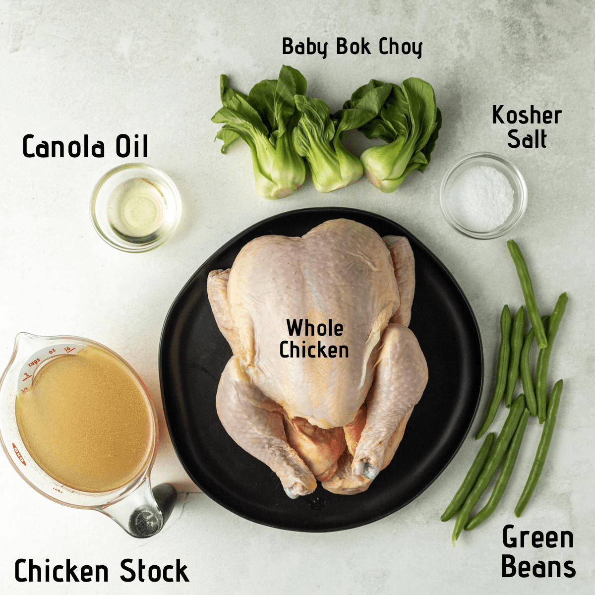 Raw ingredients on a white background, labeled: canola oil, baby bok choy, kosher salt, whole chicken, chicken stock and green beans.