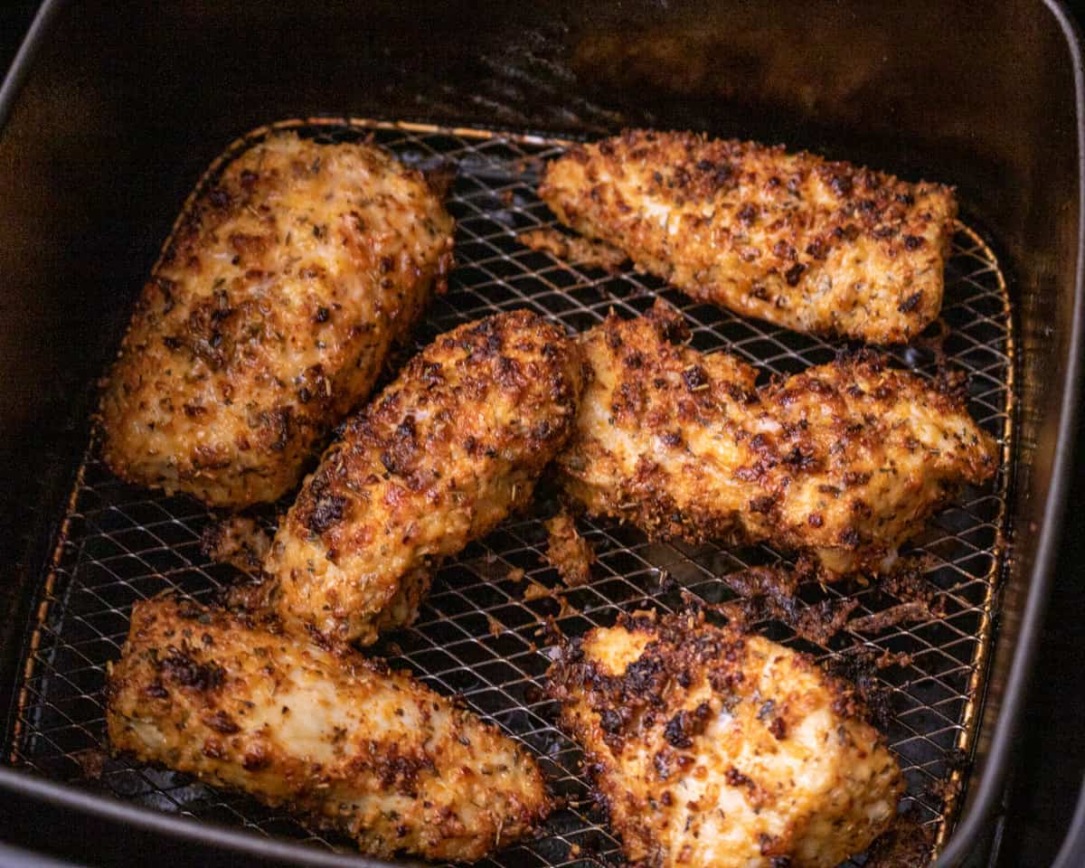 Close up of air fryer parmesan crusted chicken in air fry basket.