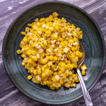 Miso butter corn on a green plate with a spoon