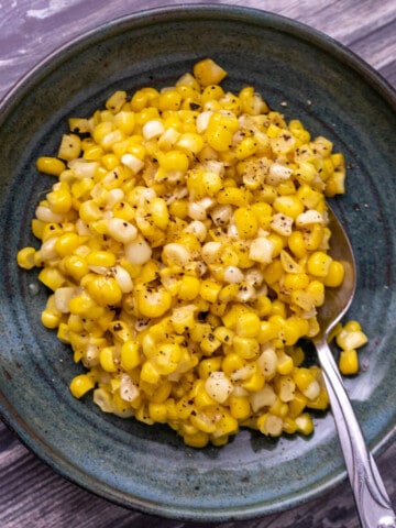 Miso butter corn on a green plate with a spoon